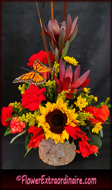 orange, yellow maroon fall and Thanksgiving floral arrangement with orange butterfly